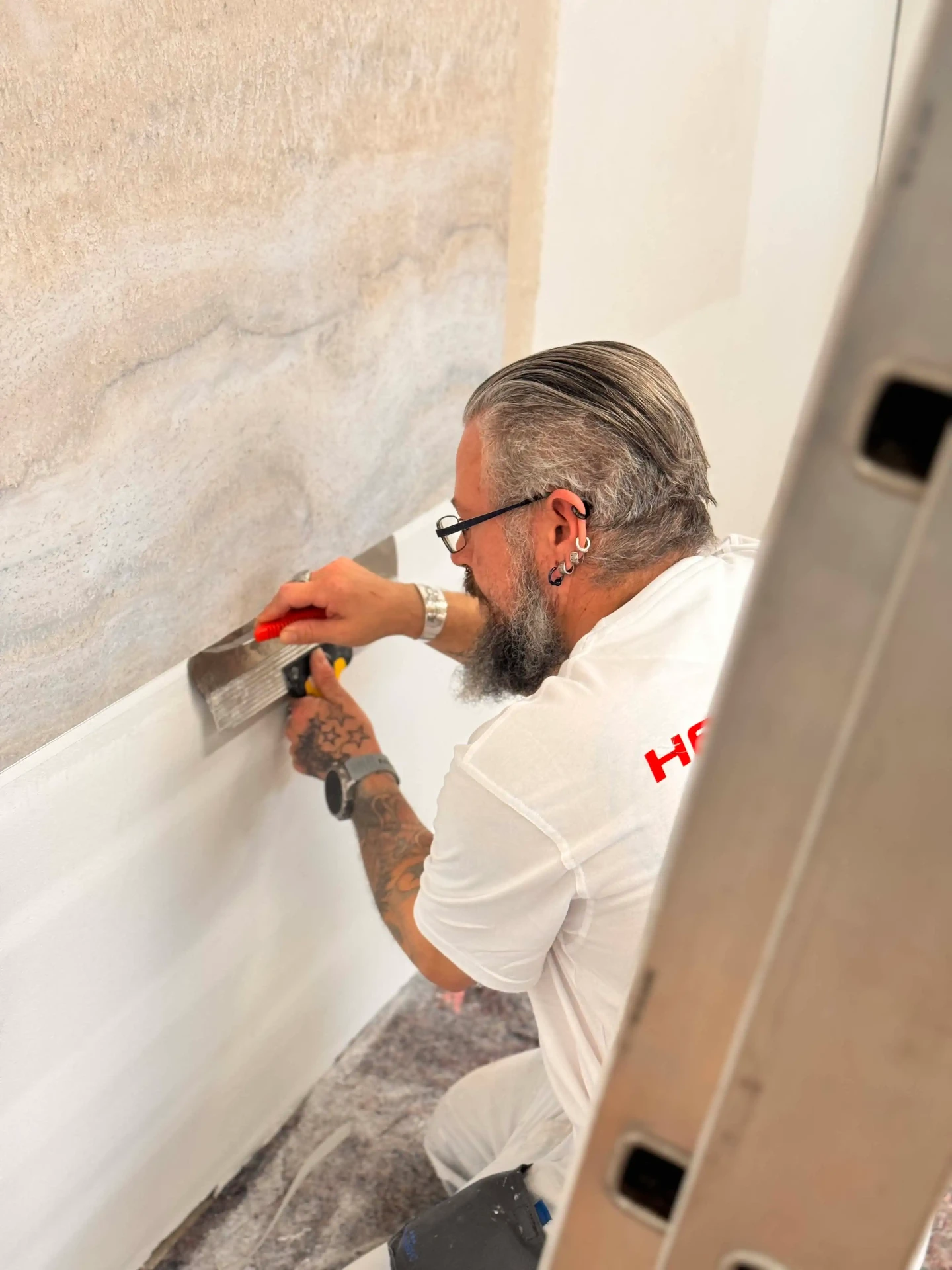 Heineking Mitarbeiter bei Tapezierarbeiten